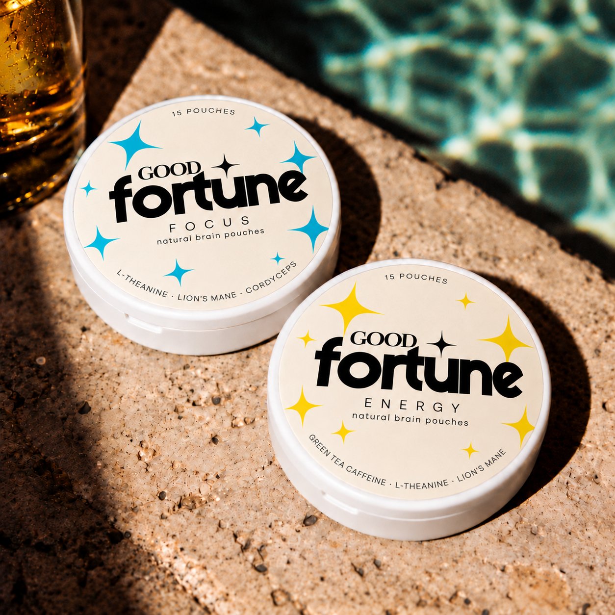 Good Fortune Focus and Energy cans on a sunlit pool edge